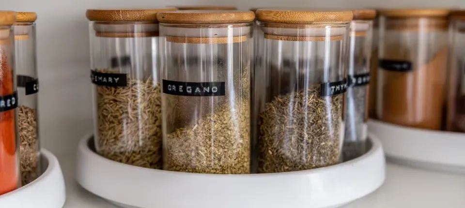 lazy susans in a cabinet holding labeled containers of grains and spices